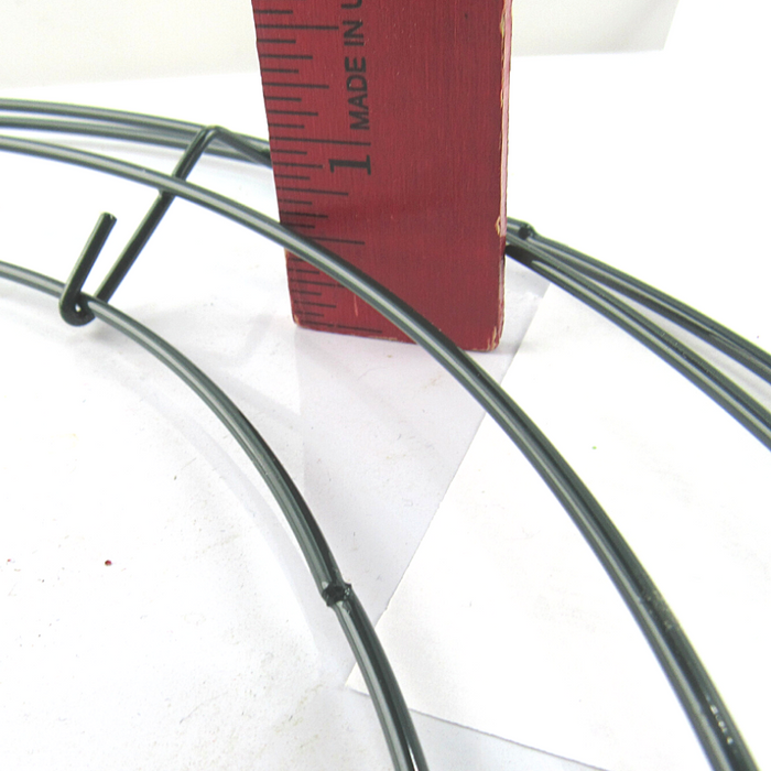 A red ruler stands vertically beside the 14 Box Wreath Frame Bundle of 10 (36004) on a white surface, showing inch measurements to indicate the wreath frames height.