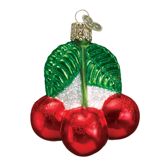 The Cherries Ornament by Old World Christmas (28050) is a hand-blown glass decoration featuring three red cherries with glittery details, two green leaves, and a gold cap with a loop for hanging.