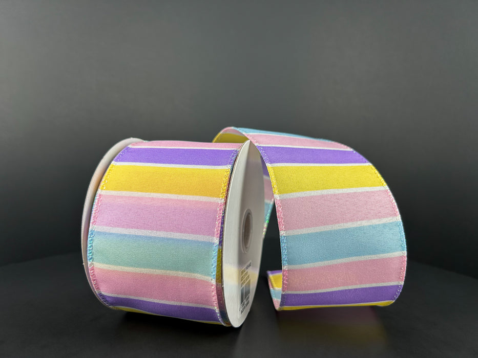 Two spools of the 2.5"X10Y Lavender-Yellow-Pink-Lt Blue-White Wide Stripes Ribbon 31402-40-02 are set against a dark backdrop, showcasing their wide pastel stripes in alternating shades of pink, yellow, lavender, light blue, and green.