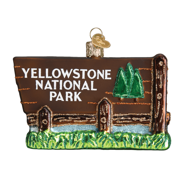 The Yellowstone National Park Old World Christmas Ornament 36173 features a wooden sign shape with two green trees, grass at the bottom, and "Yellowstone National Park" text. It has a gold loop for easy hanging—perfect for park enthusiasts.