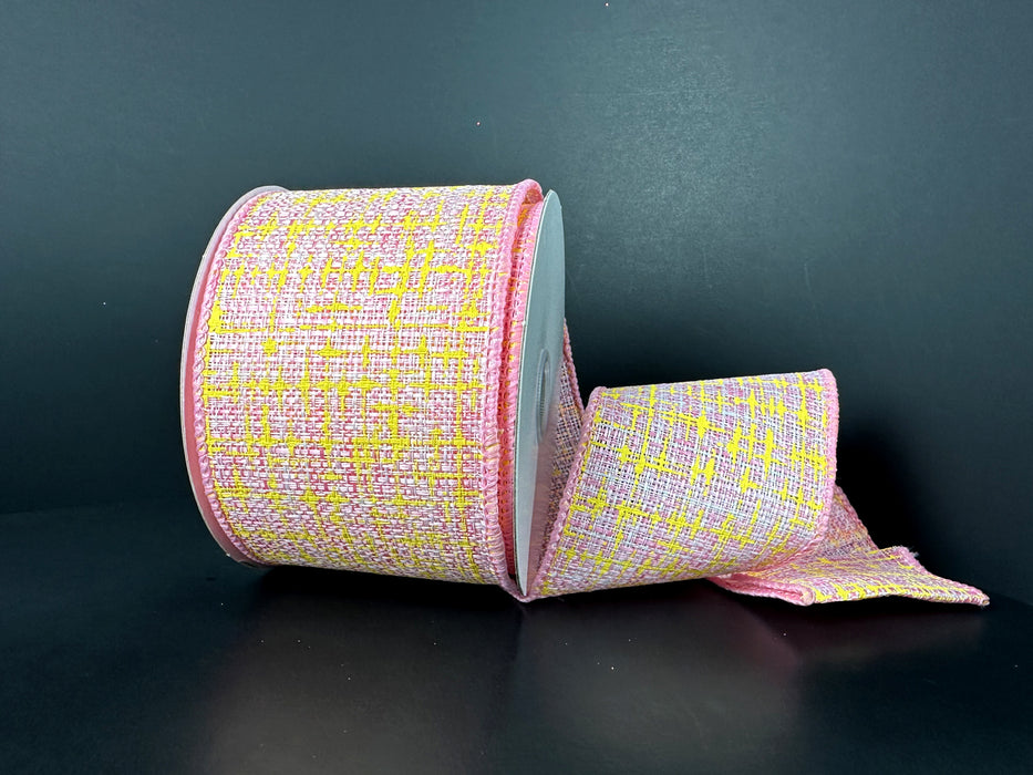 A spool of 2.5X10Y Pink White Yellow Embellished Tweed Ribbon 41522-40-03 lies on a black surface, partially unrolled to reveal its textured pattern and neatly trimmed pink edges, adding elegance.