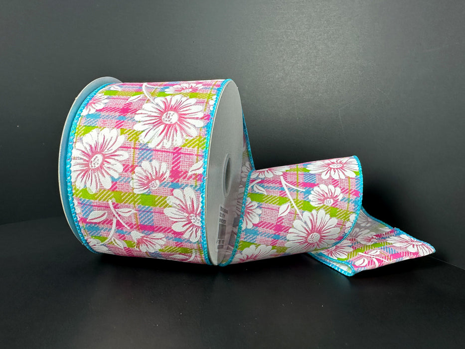 A partially unrolled roll of 2.5X10Y Pink Fuchsia Lime Aqua Satin Plaid White Gerberas Ribbon (41525-40-39) features a floral pattern in pink, white, and green against a dark background.