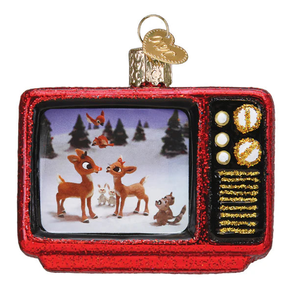 The Christmas Classic Ornament (Old World Christmas 44210) is a retro red TV made from hand-blown glass, featuring Rudolph in a snowy scene with forest animals. It has a glittery finish and a gold loop for hanging.
