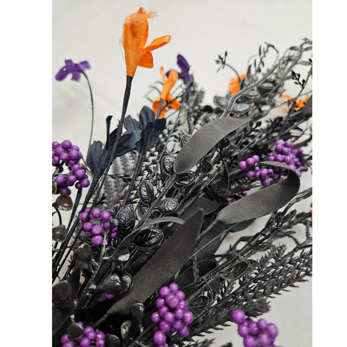 A close-up of the 24 Purple Mixed Halloween Spray 63526-PU showcases black leaves and stems, clusters of small purple berries, and bright orange fabric flowers for a striking Halloween accent against a light background.