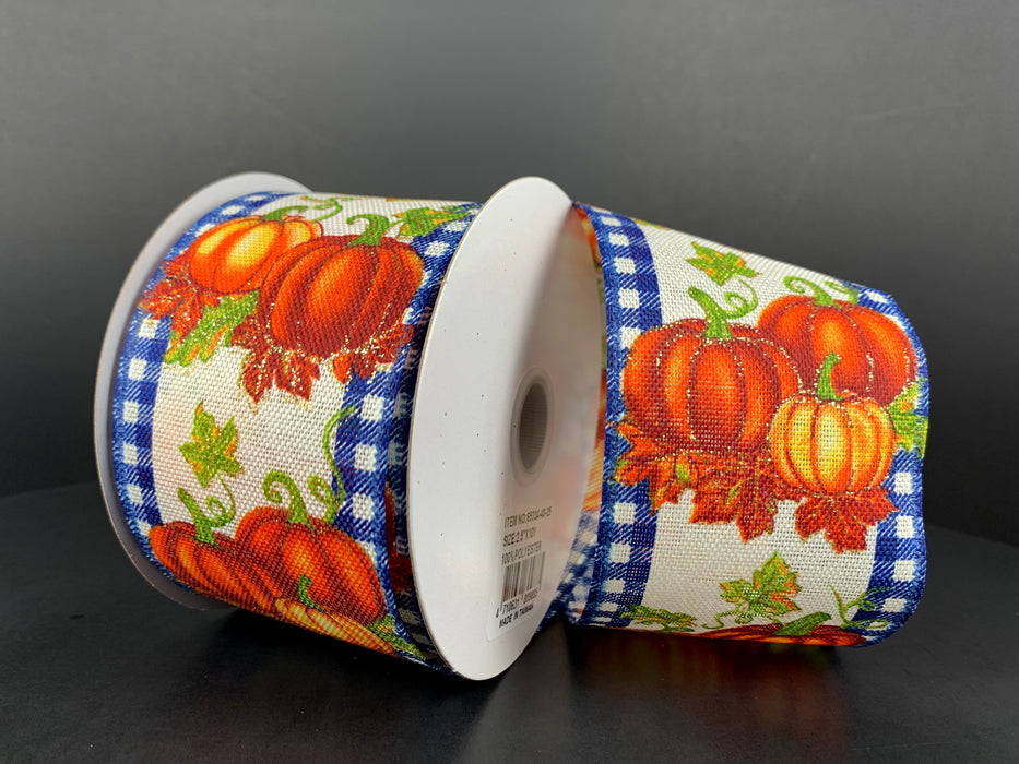 Two spools of 2.5X10Y Ivory Linen/Pumpkins Royal Gingham Edge Ribbon feature vibrant orange pumpkins and green leaves with a blue and white gingham edge, elegantly arranged on a dark background to highlight the intricate design.