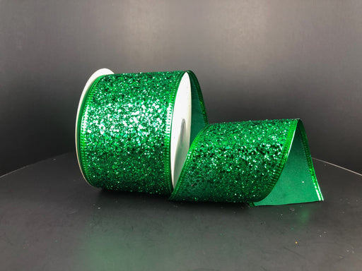 A spool of 2.5 by 10 Yard Emerald Super Glitter Ribbon (75102-40-17) is slightly unspooled against a plain black background.