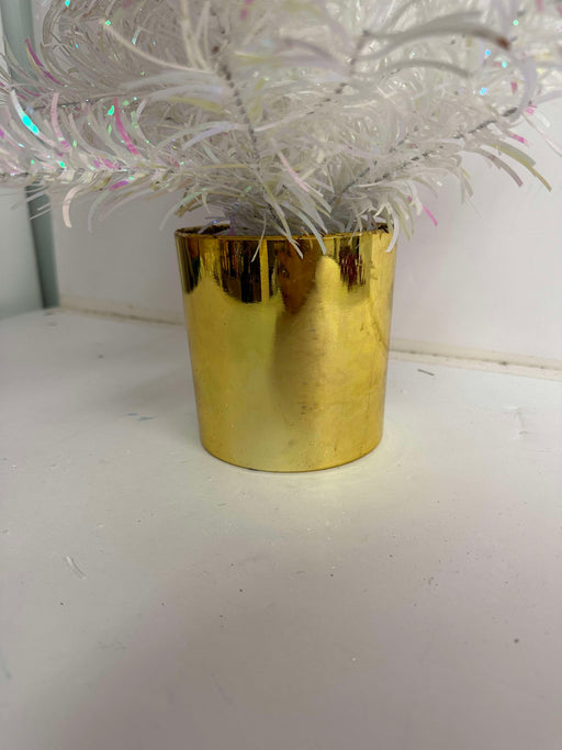 The 24 In Tinsel Tree 84578-Wtpk features sparkly white and iridescent branches in a shiny gold pot, displayed on a white surface against a light background.