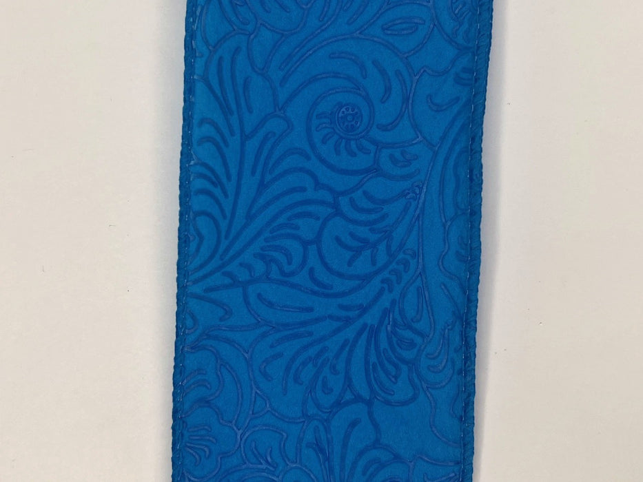 Close-up of the 2.5X10Y Turquoise Flower Embossed Ribbon (984240-39) features intricate turquoise leather with embossed floral patterns, including swirls and leaf-like shapes, adding texture and elegance.