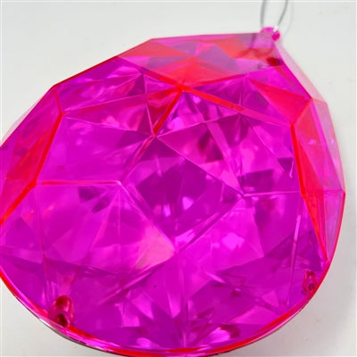 A close-up of the 6.3" x 4" x 9" Hot Pink Plastic Drop Ornament (DCORN5408HTPK), featuring a faceted, teardrop shape with bright pink, transparent plastic and geometric, reflective surfaces, set against a plain white background.