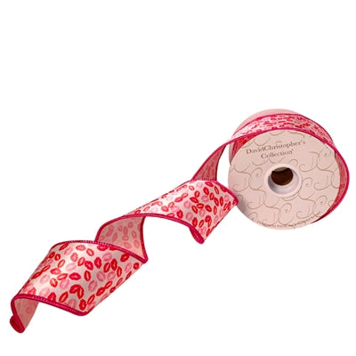 A 2.5 x 10 yards Red, Pink and White Kissy Kissy Faux Satin Ribbon (DCR3759) featuring red edges and a lips pattern, partially unrolled to display the David Christophers Collection label on the spool.