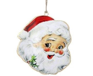The 5.5 Metal Retro Santa Ornament (Red and White, MTX71013) features a smiling Santa face with rosy cheeks, white beard, red hat, and holly sprig near his beard, hanging by a string.