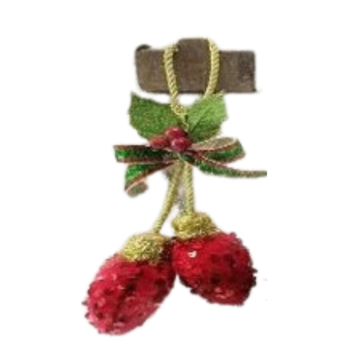 The 7.5 Sequin Bulb Drop Ornament (MTX71997) features two red, glittery pinecone bulbs with green leaves, a ribbon bow, and a red berry, all hanging from gold cords on a brown wooden piece—perfect for holiday decor.