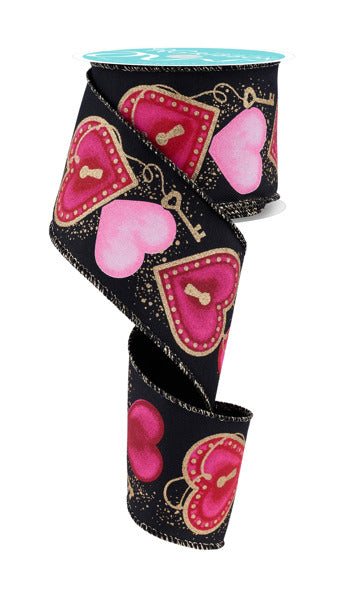 The 2.5 x 10 yd Black/Multi Heart Locks Ribbon (RGF152202) features pink, red, and gold heart lock and keyhole designs, artistically curled to display its decorative accents on a partially unrolled spool.