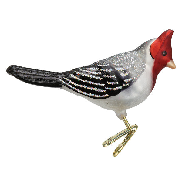 The Red-crested Cardinal Ornament (Old World Christmas 18136) features a shimmering white and silver body, a black tail, and is attached to a gold clip for easy display.
