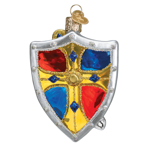 The Medieval Armor Ornament (Old World Christmas 36315) is a decorative Christmas ornament shaped like a medieval shield, with red and blue sections, a yellow cross, glitter accents, and a gold hanging loop.