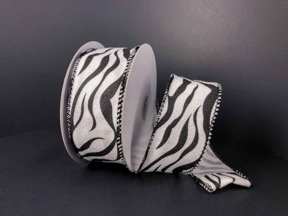 A spool of 1.5X10Y White Fleece/Zebra Stripes (41248-09-01) ribbon, partially unrolled, is displayed against a black background.