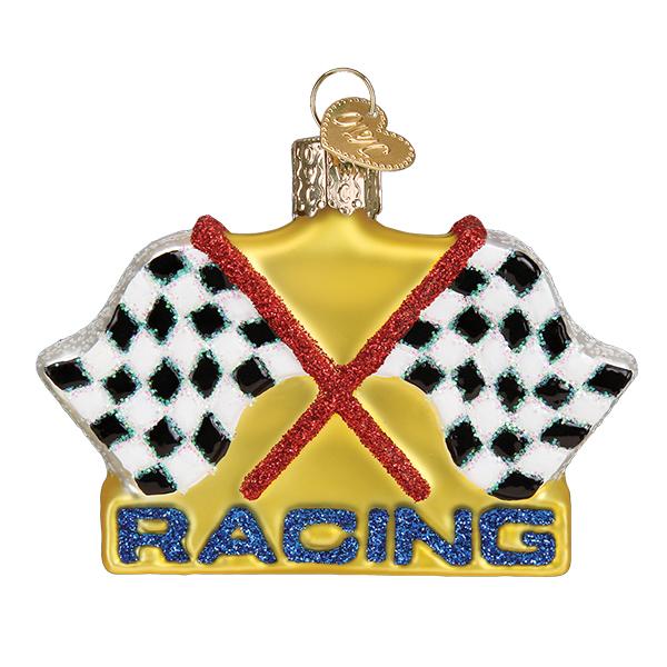 The Racing Flags Old World Christmas Ornament 44153 is mouth-blown glass with two crossed checkered flags and a red border. RACING sparkles in blue glitter on a gold background. It has a small gold loop on top for easy hanging.