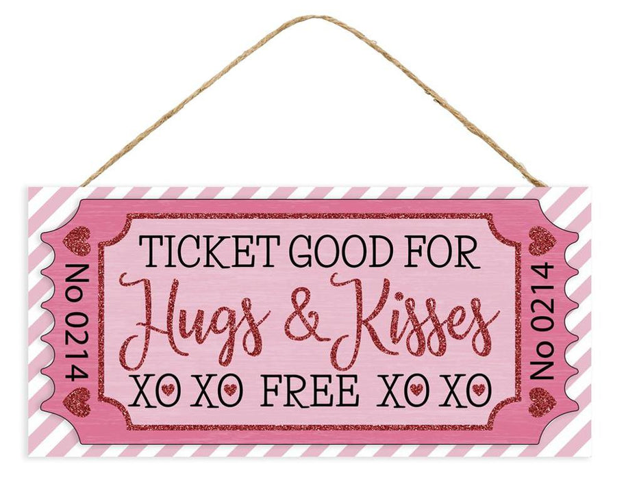 The 12.5L Glitter Ticket Hugs & Kisses Sign (AP7843) in pink/light pink/black/white is a decorative plaque shaped like a glitter ticket, featuring Ticket Good For Hugs & Kisses XO XO FREE XO XO on a striped background with heart accents and an attached rope for easy hanging.