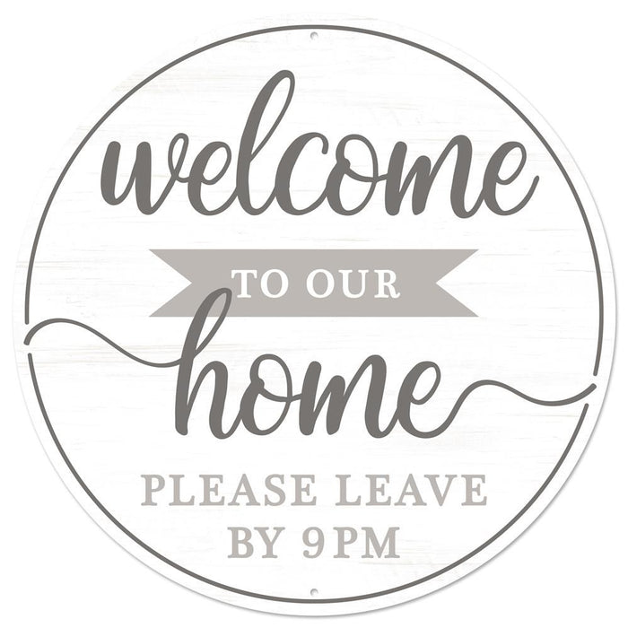 The 12 diameter round metal sign MD0905 features the text Welcome to Our Home, please leave by 9pm in gray, charcoal, and white, with the word home stylized in larger cursive font.