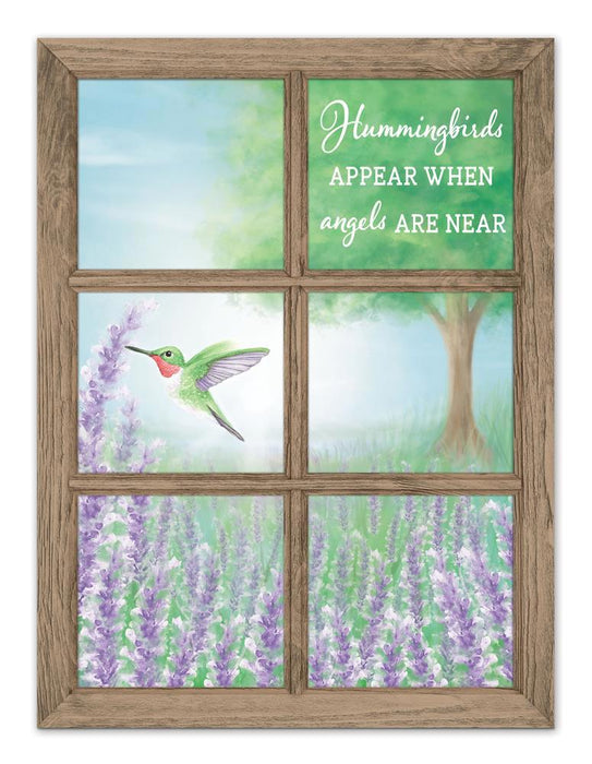 This 12.75H x 9.5L framed window sign features a hummingbird with blue and lavender flowers, a grassy field, and a tree backdrop. It reads, Hummingbirds appear when angels are near, ideal for adding peace and beauty to your space (Product: MD1351).