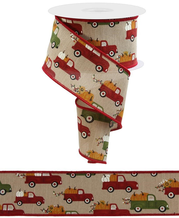 The 2.5X10Yd Pumpkin Trucks On Faux Royal Tan/Fall Multi ribbon (RGE1001J1) features pumpkin trucks and fall foliage on a beige background with red edges, partially unrolled to display its charming autumn design.