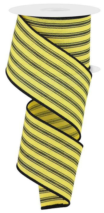 A coiled spiral of 2.5x10yd ticking stripe ribbon in yellow/black, featuring black edges, green accents, and glossy finish on a white spool with flat top and bottom. Product: RGE149429.