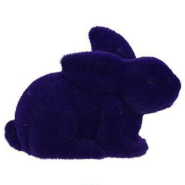 The product is an 8.5L x 6H flocked laying rabbit sculpture available in six assorted colors: purple, pink, black, green, orange, and turquoise (HE722999).