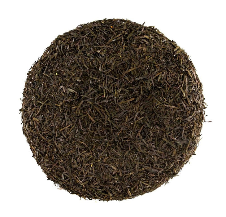 The 7 Brown Flower Center MD037004 is a circular and compact disc of dark dried tea leaves, resembling a sunflower center from above. It has a coarse texture with small leaf fragments and a uniform deep brown color indicating rich fermentation.