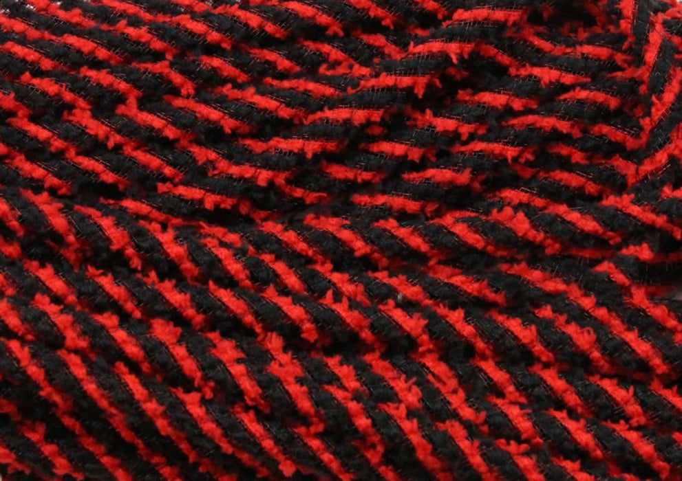 Close-up of 8Mm X 20Yd Snowdrift Deco Flex Tubing (Red/Black, RE3225K1) reveals soft woven fabric with bold red and black diagonal stripes and prominent raised stitches, evoking a vivid winter snowdrift pattern.