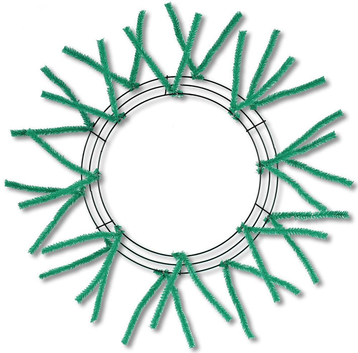 The 24 Pencil Wreath Emerald Green Non-Metallic XX750406 has textured emerald green stems resembling tinsel, arranged circularly and extending outward, all set against a plain white background.