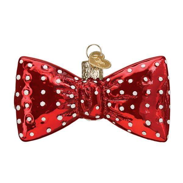 The Bowtie 32374 Old World Christmas Ornament is a shiny red, hand-painted glass decoration with white polka dots and a gold hanging loop, inspired by classic Old World Christmas charm.