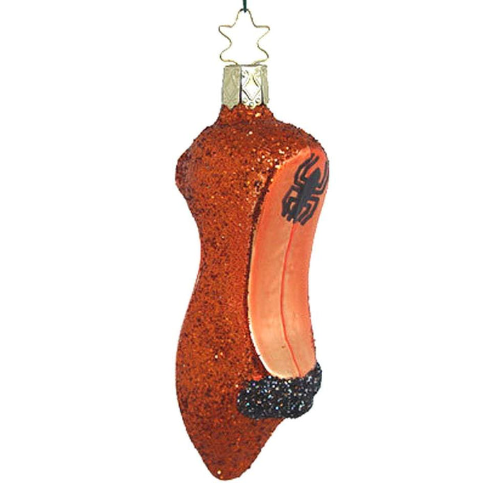 The Witchs Slipper Halloween Christmas Ornament by Inge-Glas of Germany (4-170-03) features a glittery red shoe with a black spider heel, star hook, and black glittery bow—an ideal handcrafted piece for your holiday collection.