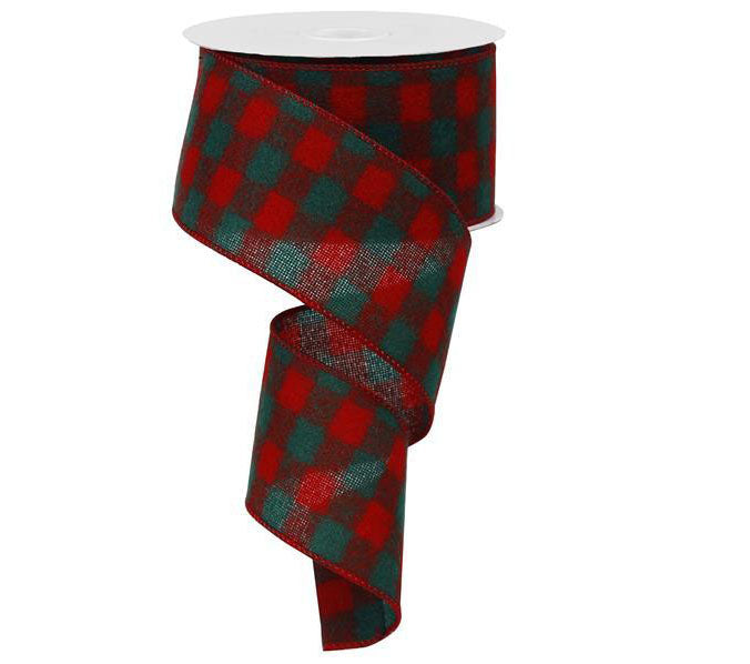 A partially unrolled spool of 2.5 Red Emerald Green Fuzzy Flannel Check Ribbon RG0102874, featuring a red and green buffalo plaid pattern with an acrylic wire edge.