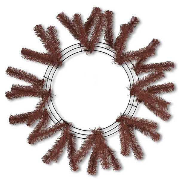The 24" Work Wreath Chocolate Brown XX748840 features a symmetrical design with artificial pine branches partially covering the chocolate brown frame. The branches extend outward evenly, forming a perfect circular pattern while leaving the center empty.