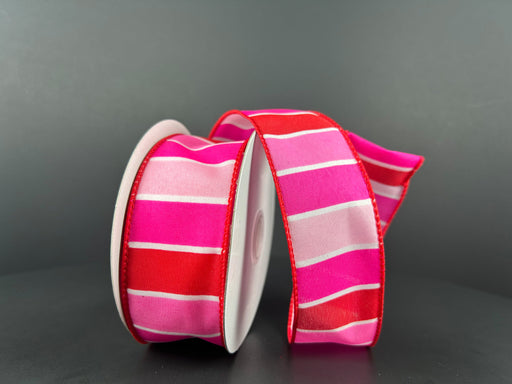 Two rolls of the Fuchsia-Red-Pink-White Wide Stripes ribbon, measuring 1.5 inches by 10 yards (product number 11407-09-28), are displayed. They feature vibrant fuchsia and red colors accented with horizontal white stripes and are partially unrolled against a dark background.
