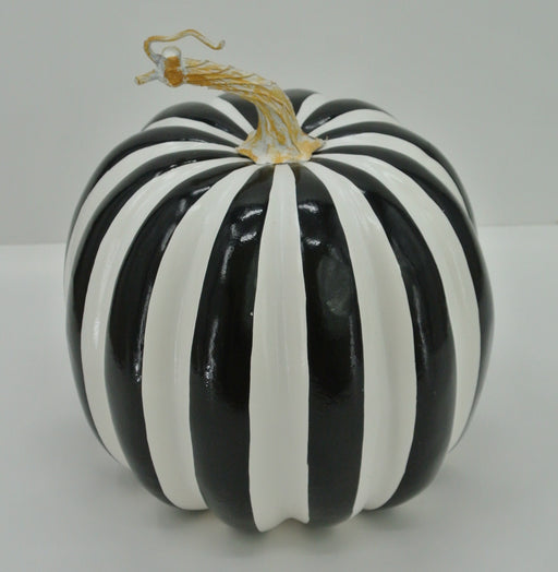 The 7.5 Black and White Stripe Pumpkin 23066-BKWT features alternating black and white vertical stripes and a natural dried stem, displayed on a plain white surface.