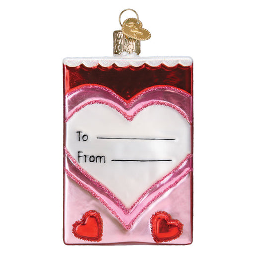 A Conversation Hearts Candy Old World Christmas Ornament 32623 shaped like a rectangular valentine card, featuring a white heart in the center with lines for To and From and two small red hearts at the bottom.
