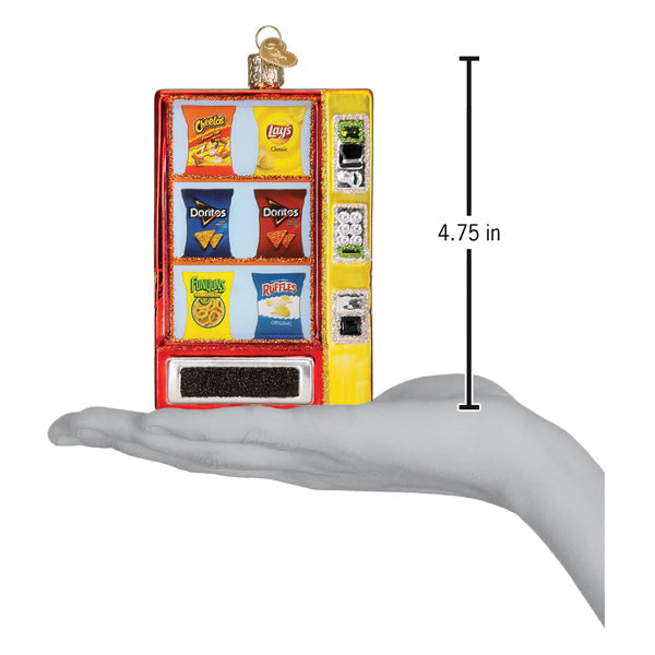 A hand holds a 4.75-inch Frito Lay Vending Machine Old World Christmas Ornament 32624, which features various snack bags in the display window.