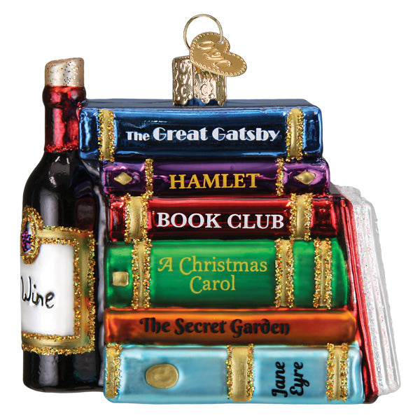 Book Club Old World Christmas Ornament 32653, a glass ornament shaped as a stack of books titled The Great Gatsby, Hamlet, Book Club, A Christmas Carol, The Secret Garden, and Jane Eyre, sitting next to a wine bottle.
