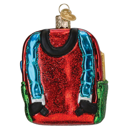 First Day of School Old World Christmas Ornament 32655, a glass ornament shaped like a red glittery backpack with blue straps and green side pockets.