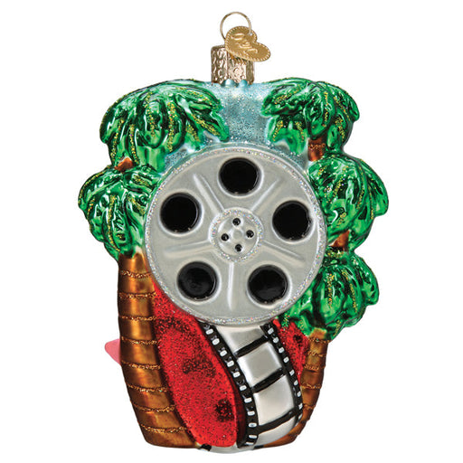 A glass Hollywood Walk of Fame Old World Christmas Ornament 36344 shaped like a film reel nestled between two palm trees.