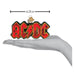 A hand holding an AC/DC Old World Christmas Ornament 38074, a 4.25-inch long glass ornament shaped like a red and black lightning bolt logo.