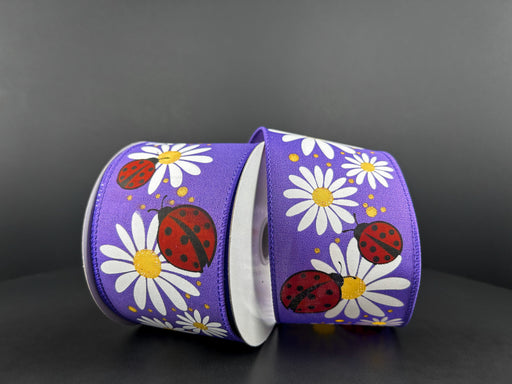 The 2.5X10Y Purple Satin/Ladybug-Daisies Ribbon 41116-40-11 displays white daisies and red ladybugs with black spots on a purple satin base, standing out against a dark gray backdrop for a vibrant and playful look.