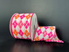 The 2.5X10Y White Iridescent Glitter Satin/Pink-Fuchsia-Peach Argyle Diamonds Ribbon features a pink, fuchsia, and peach argyle pattern on black. Unrolled, it showcases its detailed design beautifully.