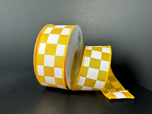 A spool of 1.5X10Y Yellow Satin/White Racechex Ribbon 41531-09-49 is placed on a black background, with one end unfurled to highlight its checkered design.