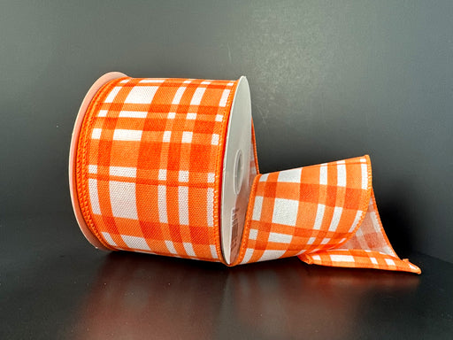 The 2.5X10Y Orange Watercolor Tuttola Plaid Ribbon 41546-40-19, with its wired orange checkered pattern, is partially unrolled on a dark background.