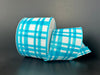 The 2.5X10Y Turquoise Watercolor Tuttola Plaid Ribbon (41546-40-39) is partially unrolled on a plain dark background, showcasing its turquoise and white pattern.