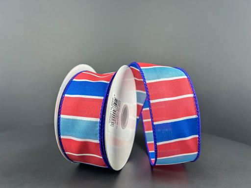Two spools of 1.5X10Y Red-Royal Blue-Lt Blue-White Wide Stripes Ribbon rest on a gray surface against a matching background.