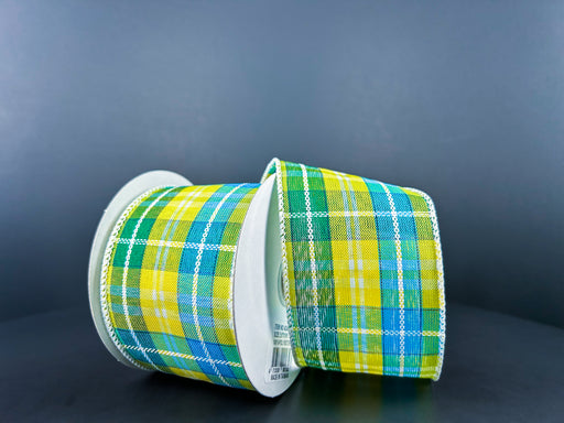 Two rolls of Turquoise-Green-Yellow Kennedy Plaid Ribbon (2.5X10Y 42420-40-49) are partially unrolled against a dark background, showcasing their vibrant colors and white-edged pattern.