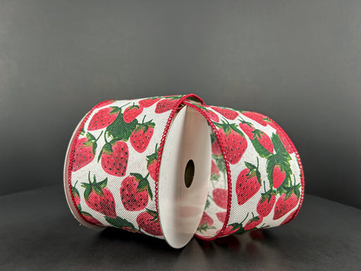 The 2.5X10Y Ivory Linen/Strawberries Ribbon 42450-40-18 features red strawberries with green leaves on ivory linen. The wired ribbon, adorned with red stitched edges, is elegantly displayed against a plain dark backdrop.